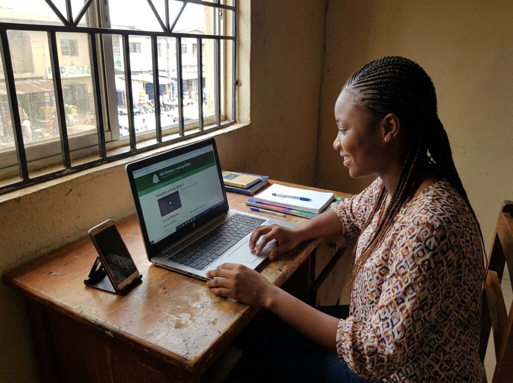 Student studying at home with structured online setup; screen showing recorded lectures, course modules, and assignments; simple, practical learning environment; represents ABU distance learning programs and flexible degree programs
